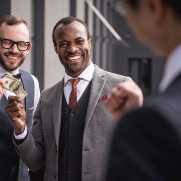 young smiling multiethnic businessmen in formalwear meeting outdoors, business team meeting